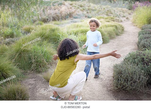 Boy running to mother on trail