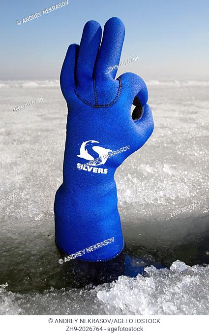 Diver's hand giving the Ok sign, subglacial diving, ice diving, in the frozen Black Sea, a rare phenomenon, last time it occured in 1977, Odessa, Ukraine