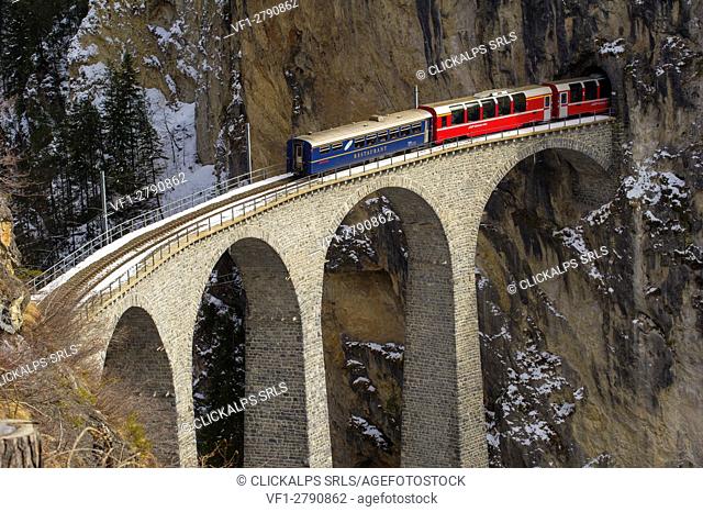 Red Bernina Express train and the Landwasser viaduct. Engadine, Switzerland, Europe