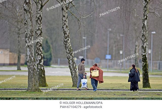 Refugees walk across the site of the Camp Bad Fallingbostel Ost refugee accommodation in Bad Fallingbostel, Germany, 30 March 2016