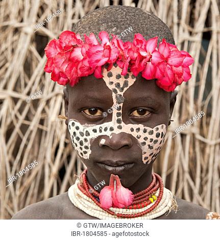 Karo girl with a floral headband, facial paintings, colorful necklaces and lip piercing, portrait, Omo river valley, Southern Ethiopia, Africa
