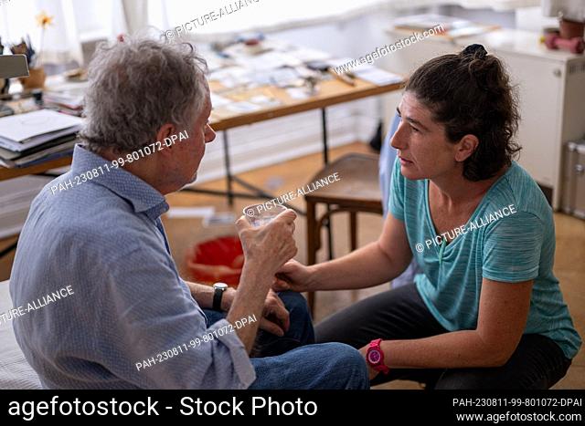PRODUCTION - 31 July 2023, Berlin: During a home visit, nurse Ramona Rössner talks to her patient Andreas Seltzer, who is in need of care