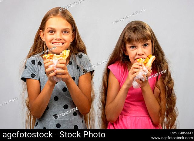 Two girls are funny eating bread