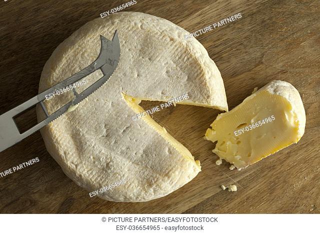Reblochon de Savoie cheese from raw cows milk with a slice