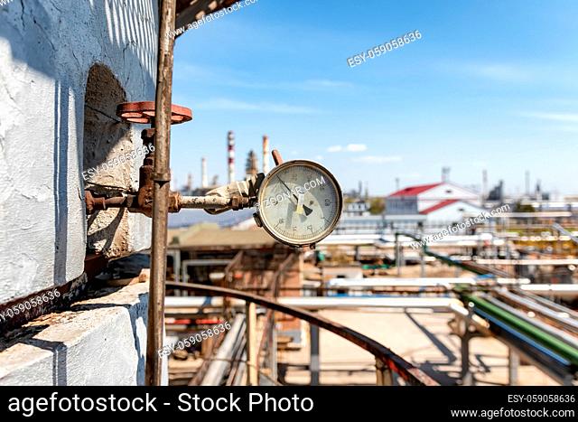 Old reliable pressure gauge mounted on a large column in an oil refinery