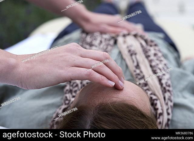 Woman on a couch and a therapist touching her head and stomach
