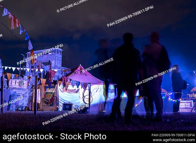 09 September 2022, Saxony-Anhalt, Magdeburg: Festival visitors stand on the Elbe meadows in front of the Magdeburg lift bridge, a landmark of the city