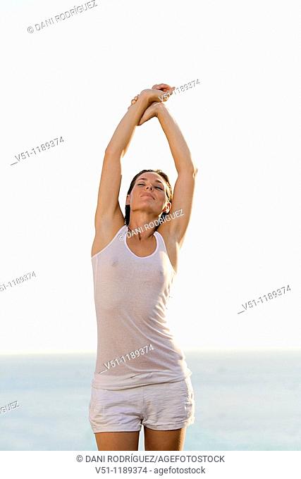 Brunette woman stretching by the sea