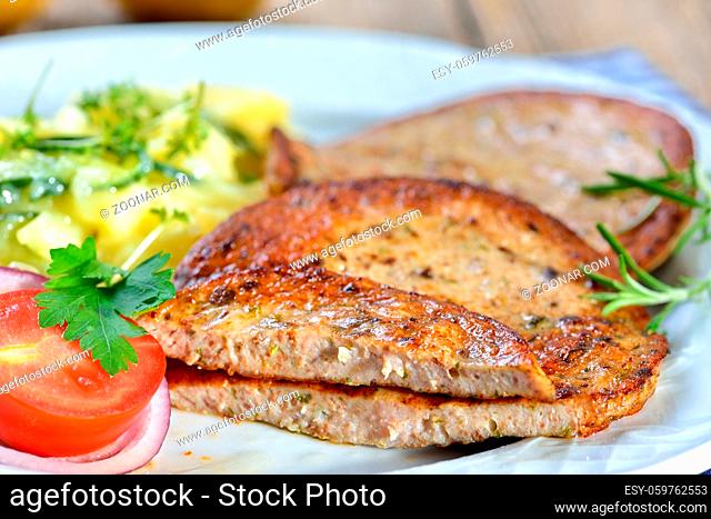 Eine bayerische Spezialität: Gebratene Milzwurst mit Kartoffelsalat - Bavarian food: Fried sausage with pieces of spleen served with potato salad