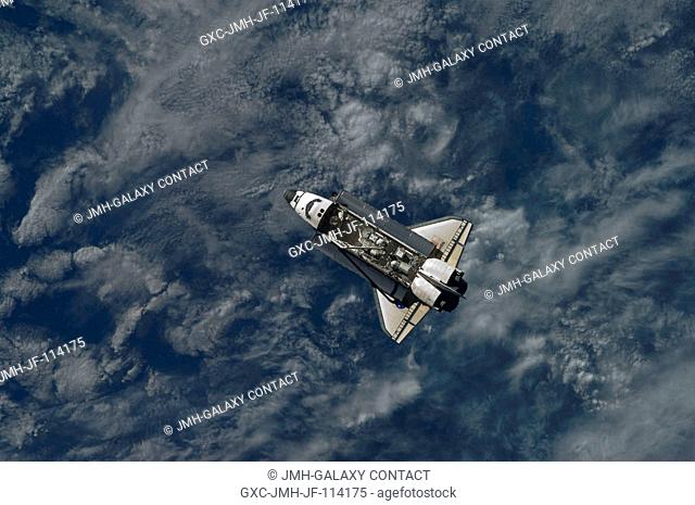 Backdropped by a blue and white part of Earth, Space Shuttle Atlantis is featured in this image photographed by an Expedition 21 crew member as the shuttle...