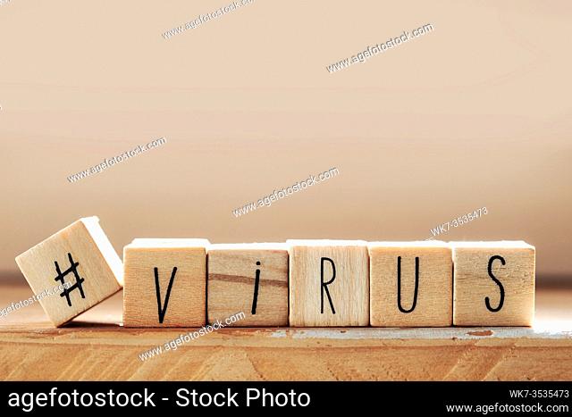 The word Virus on wooden cubes with a hashtag, Medical concept covid-19 close-up