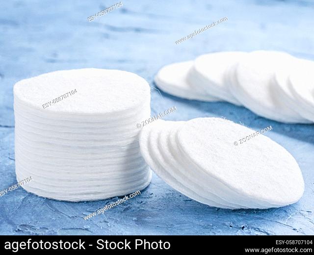 cotton pads on blue concrete background close up