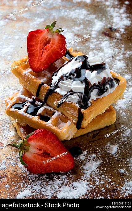waffle with chocolate syrup on a sugary steel plate