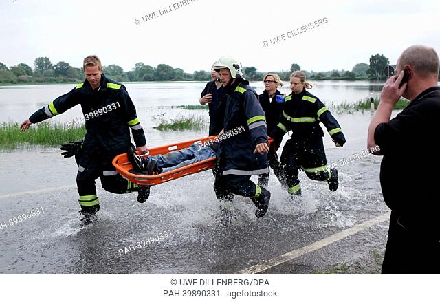 Firefighters carry a woman on a stretcher in the floodplain of the Leine river in Hanover, Germany, 30 May 2013. The woman had an accident with her bicycle in...