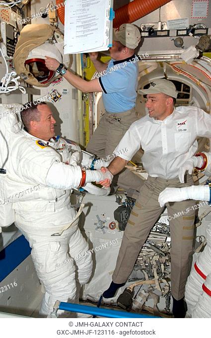 Astronaut Richard Arnold, STS-119 mission specialist, attired in his Extravehicular Mobility Unit (EMU) spacesuit, and astronaut Lee Archambault