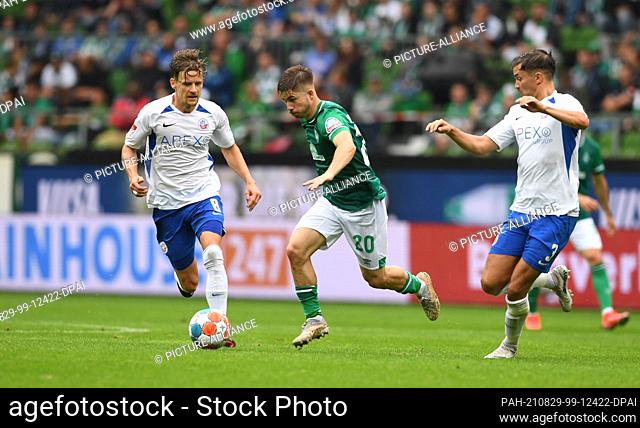 29 August 2021, Bremen: Football: 2. Bundesliga, Werder Bremen - Hansa Rostock, Matchday 5. Werder's Romano Schmidt fights for the ball against Rostock's...