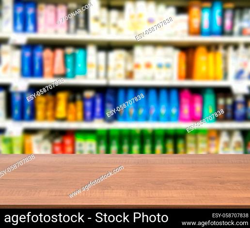 Wooden board empty table in front of blurred background. Perspective brown wood board over blurred colorful supermarket products on shelvest - mock up for...