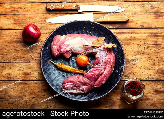 Tasty raw pork meat for cooking. Raw meat tenderloin and spices set on cutting board