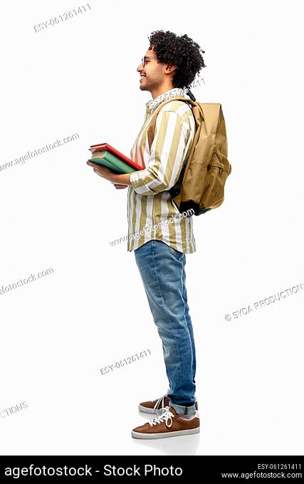 smiling man in glasses with backpack and books