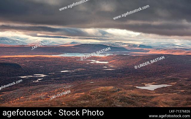 Mountain landscape with lakes and snow-covered peaks in Pieljekaise National Park in autumn in Lapland in Sweden