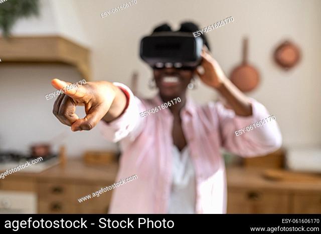 Virtual reality. African woman in pink clothes in vr glasses looking excited