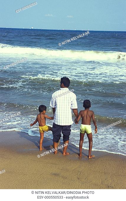 Father & two sons enjoying in sea marina beach , bay of bengal , Chennai Madras , Tamil Nadu , India