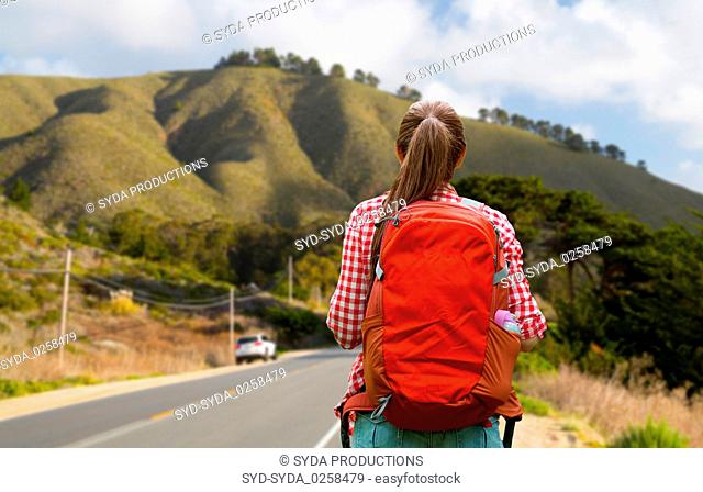 woman with backpack traveling over big sur hills