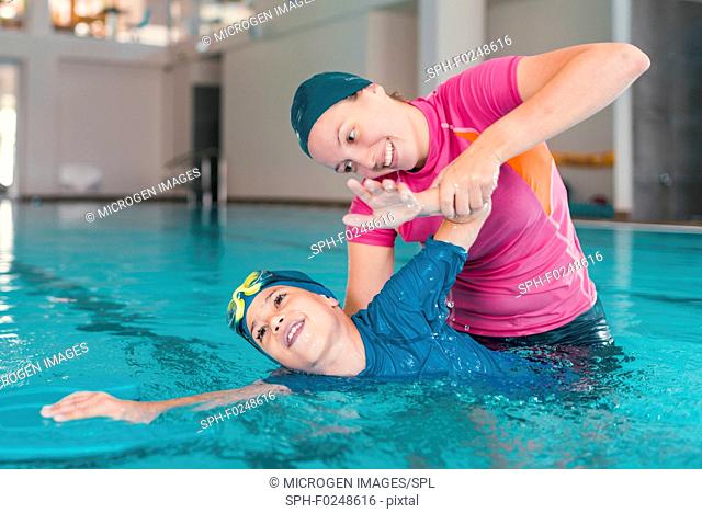 Boy in swimming class with instructor