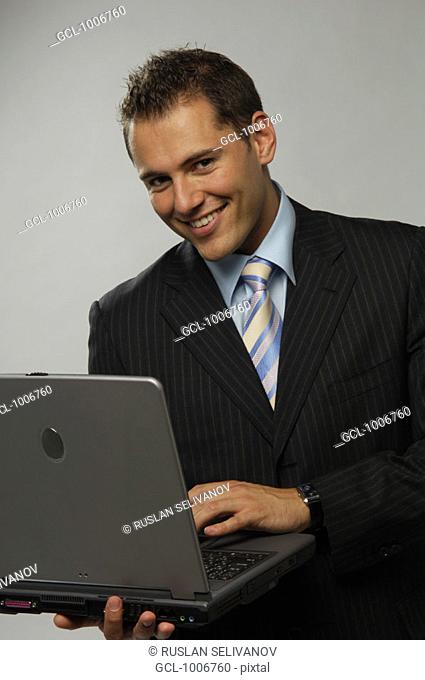 Portrait of a smiling businessman with laptop