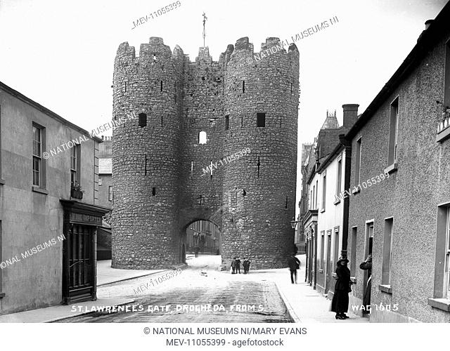 St Lawrence's Gate, Drogheda, from S. - a view from the other side of the street of the stone gate tower, there are people in the foreground