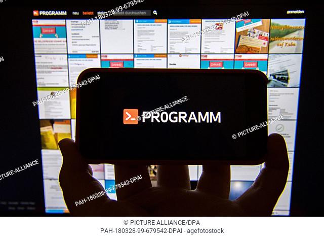 28 March 2018, Germany, Munich: The logo of the imageboard 'Pr0gramm' can be seen on a mobile phone screen in front of a laptop showing the website