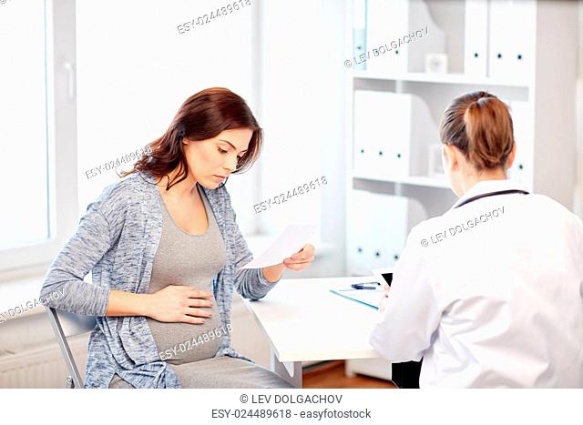 pregnancy, gynecology, medicine, health care and people concept - gynecologist doctor with prescription and pregnant woman meeting at hospital