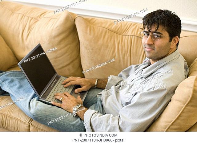 High angle view of a mid adult man working on a laptop