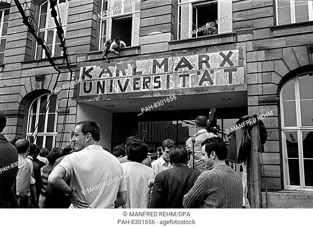 Opponents of the renaming attempt to remove the sticker ""Karl Marx Universität"" above the main entrance of the Johann Wolfgang Goethe University in Frankfurt...