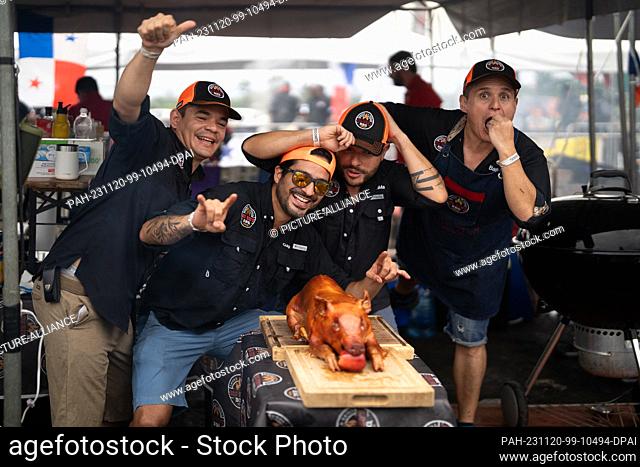 19 November 2023, Costa Rica, San Jose: The Big Red's BBQ team from Costa Rica pose with their finished piglet. Photo: Carlos Herrera/dpa