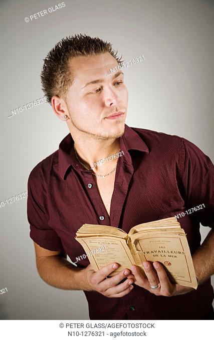 Young man holding a French book