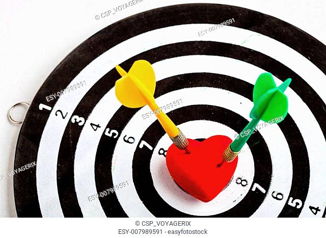 Black white target with two darts in heart love symbol as bullseye