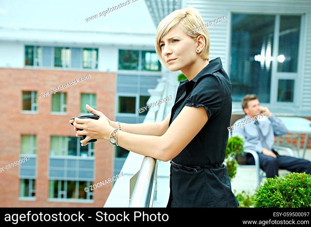 Businesswoman having break on office terrace outdoor drinking coffee