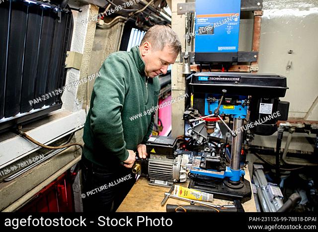 15 November 2023, Lower Saxony, Oldenburg: Roland Sandkuhl, a self-employed train driver from Oldenburg, works at a built-in workbench in his 1965 DB V 169...