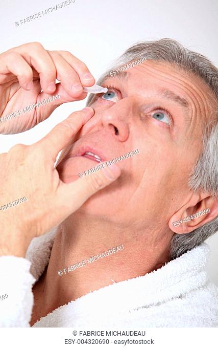 Senior man putting eye drops