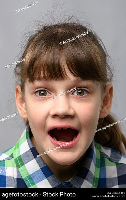 Portrait of a genuinely surprised ten-year-old girl with closed eyes, European appearance, close-up
