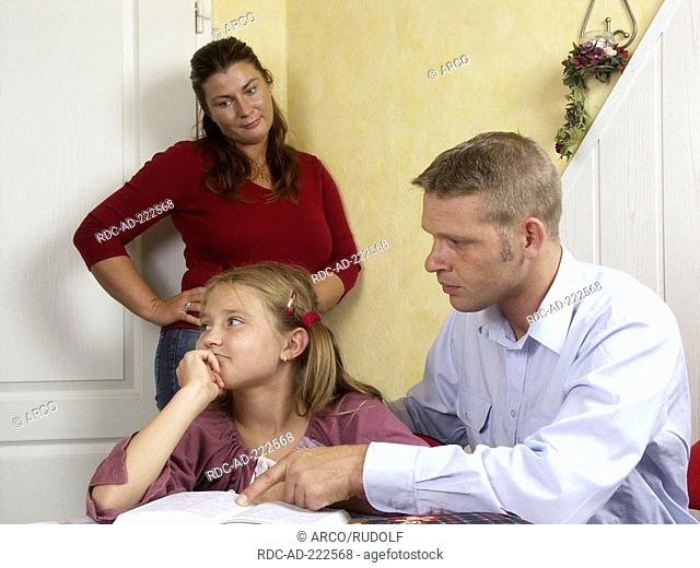 Father helping daughter with homework, mother watching, help, tutoring, private lessons