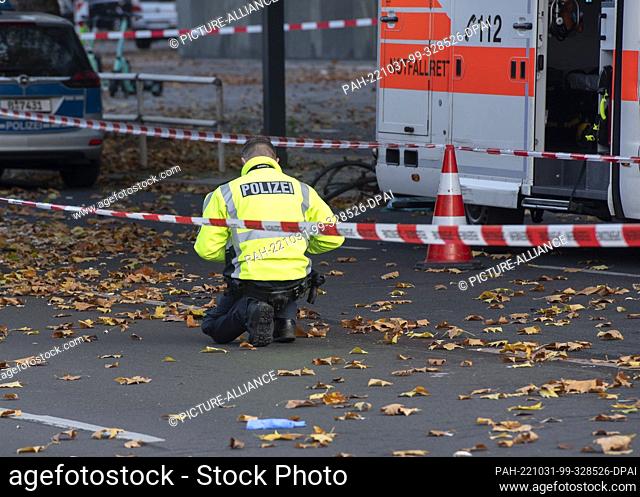 31 October 2022, Berlin: A police officer secures traces on the Bundesallee in Berlin-Wilmersdorf, where a cyclist was fatally injured in the traffic accident...