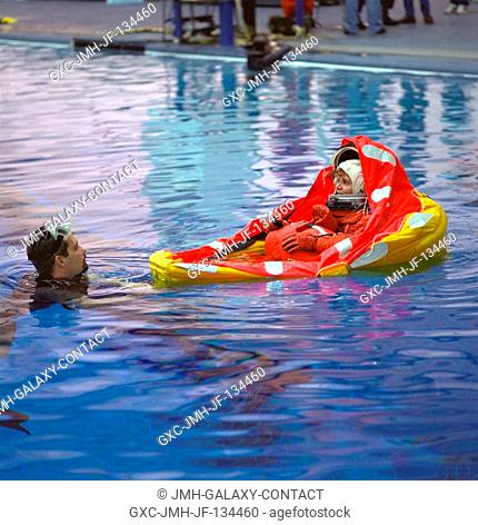 Astronaut Julie Payette is assisted by a SCUBA-equipped diver during emergency bailout training. The STS-96 mission specialist has deployed a life raft...