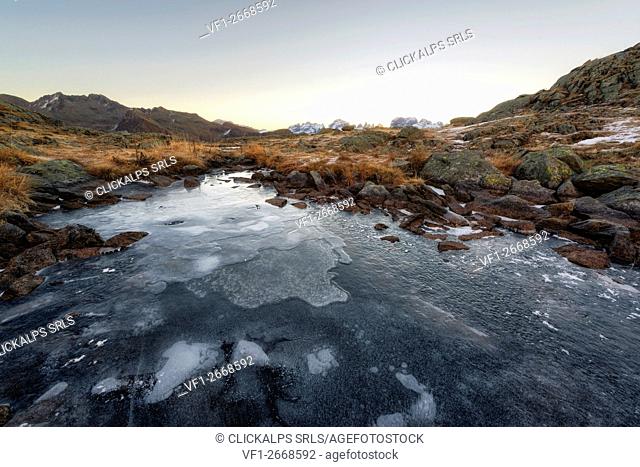 Italy, Trentino Alto Adige, Adamello Brenta Park, Nambrone valley, Dawn at frozen Black Lake, in background Brenta group