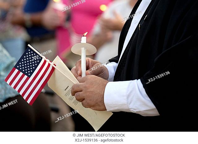 Dearborn, Michigan - A Muslim imam holds a candle and flag during an interfaith 'Remembrance and Unity Vigil' at The Henry Ford museum commemorating the tenth...