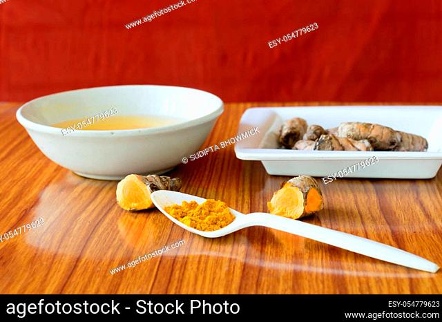 Table spoon of Pure Turmeric Haldi Powder. Haldi turmeric milk recipe. Coronavirus Anti viral inflammatory food and drink background