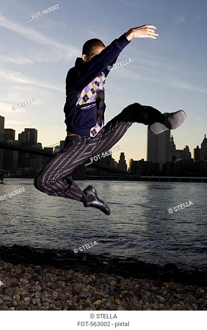 A man dancing with the Manhattan skyline behind