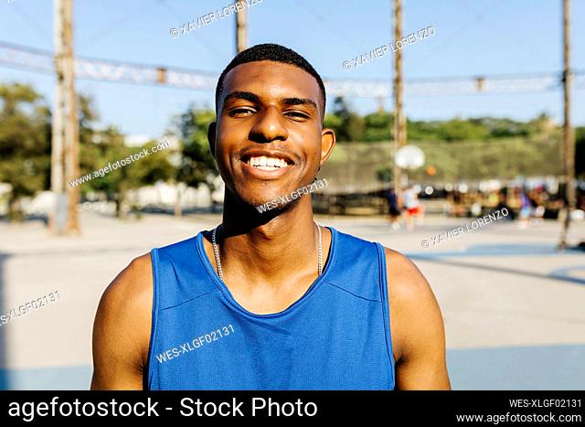 Young man smiling at basketball court
