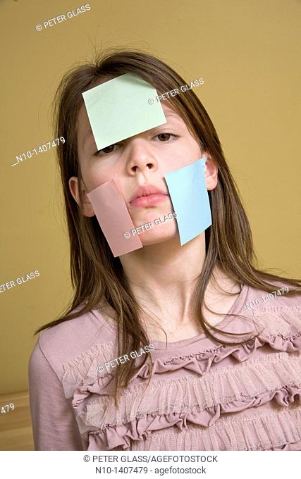 Preteen girl with post-it notes on her face